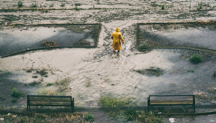 Flooded city  and man with yellow rainy 