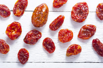 sun dried whole tomatoes on white wood table background