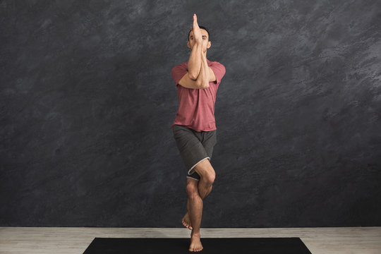 Young flexible man practicing yoga at gym - Powered by Adobe