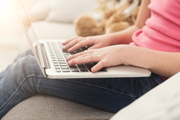 Little girl hands on laptop keyboard close up