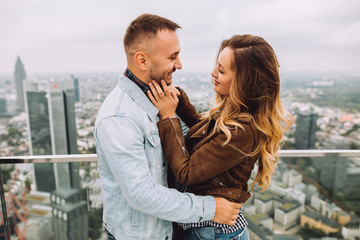 Young couple in love embraces on the roof of a skyscraper in Germany.
