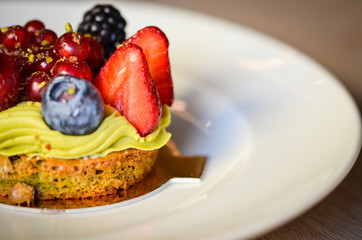 delicious fresh tarts with fruits - strawberry, blackberry, raspberry, red berry & pistachio cream