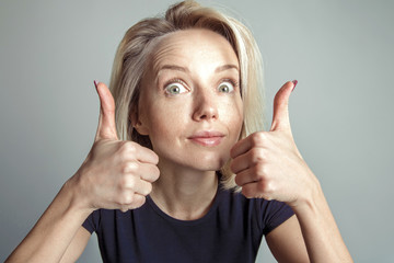 Blonde woman shows two thumbs up