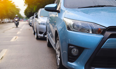 Closeup of front side of blue car parking beside the street in rainy day.