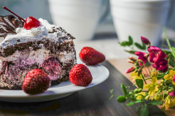 Slice of cake with cherries and strawberries