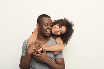 Obraz premium Black man piggybacking girlfriend at white studio