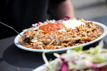 Mann isst Dönerteller mit Huhn und Salat bei Mittagspause