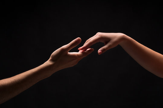 Hands of man and woman in love, isolated on black