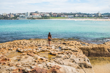 Woman looking at the beach next to Sydney