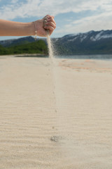 Hand pours the sand