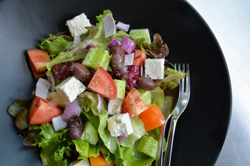 Greek salad in black bowl