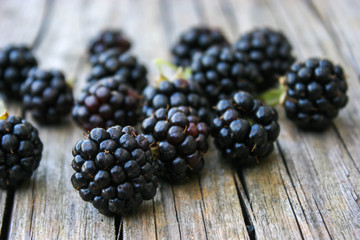 Blackberry scattered on a wooden background. Fresh, ripe blackberries. Bramble. Dewberry. 