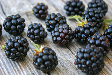 Blackberry scattered on a wooden background. Fresh, ripe blackberries. Bramble. Dewberry. 