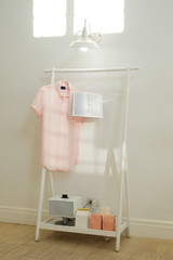 Fototapeta na wymiar Pink t-shirt and book hanging on the tripod white background.