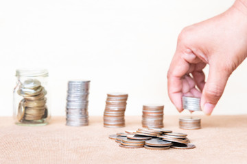 Saving money concept. Finger hold stack coins to arrangement with shown concept of growing business and wealthy.