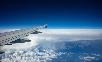 Fototapeta na wymiar Plane wing on blue sky background