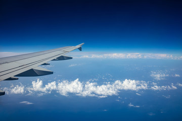 Plane wing on clear blue sky background