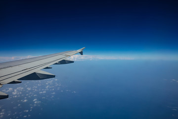 Plane wing on clear blue sky background