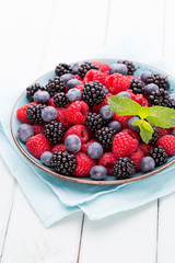 Fresh raspberries in a plate on a  vintage background.