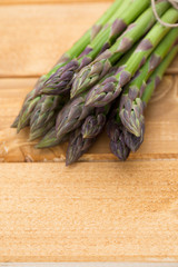 Bunch of fresh asparagus on wooden table.