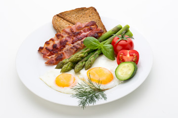 Fried eggs with bacon on the wooden table.