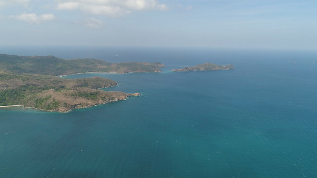 Aerial view of coast with beaches, island Limbones, lagoons and coral reefs. Neela cove, Philippines, Luzon. Coast ocean with turquoise water. Tropical landscape in Asia.