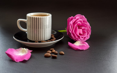 coffee with pink rose on dark leather surface