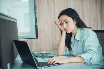 Asian woman working in office,young business woman stressed from work overload with a lot file on the desk,Thailand people