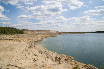 Fototapeta na wymiar Flooded open pit quarry ore clay mining with blue water