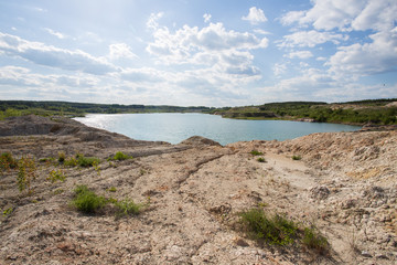 Fototapeta na wymiar Flooded open pit quarry lake ore clay mining with blue water