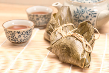 Zongzi - Traditional Dragon Boat Festival dumpling. Hand drawn watercolor painting isolated on wood background.