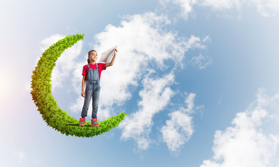Concept of careless happy childhood with girl on green moon