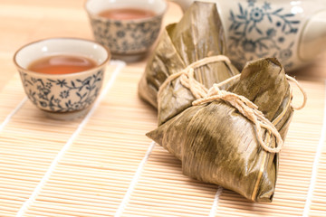 Zongzi - Traditional Dragon Boat Festival dumpling. Hand drawn watercolor painting isolated on wood background.