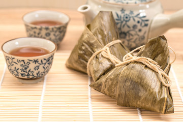 Zongzi - Traditional Dragon Boat Festival dumpling. Hand drawn watercolor painting isolated on wood background.