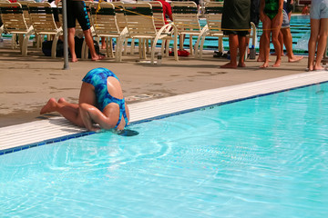Humorous image of a girl in bathing suit cooling her head  in a pool