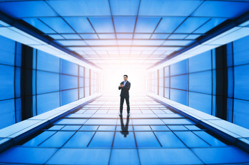 businessman walking in building tunnel looking and going to bright way start up to successful concept.