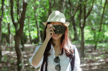 attractive woman adventure hiker go to trekking in the forest sightseeing natural at holiday travel concept. photographer using camera take a photo.