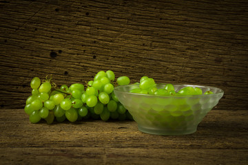 grapes green with bowl on old wood