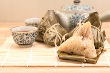 Zongzi - Traditional Dragon Boat Festival dumpling. Hand drawn watercolor painting isolated on wood background.