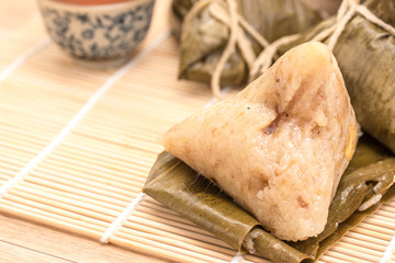Zongzi - Traditional Dragon Boat Festival dumpling. Hand drawn watercolor painting isolated on wood background.