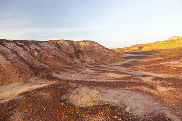 Multicolored red, orange and yellow soil with with fragments of saline soil and lichen under a bright blue sky in Eastern Kazakhstan