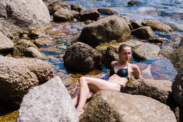 beautiful girl in a bikini among the rocks