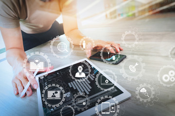 Obraz premium businessman working with digital tablet computer and smart phonewith digital business strategy layer effect on wooden desk as concept