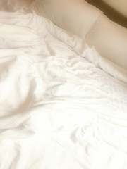 Crumpled white bed linen close up