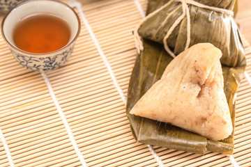 Zongzi - Traditional Dragon Boat Festival dumpling. Hand drawn watercolor painting isolated on wood background.