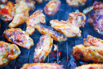 Chicken wings on barbeque grill with fire