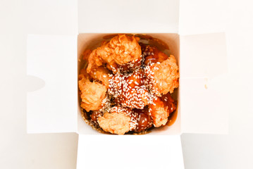 Chicken in breadcrumbs with sesame and in sweet sauce. Fast food. Take away.