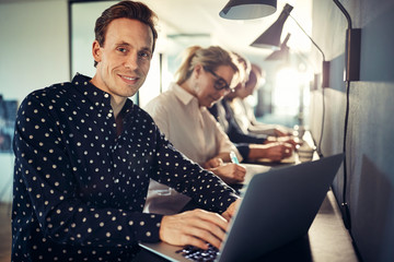 Smiling young designer working with colleagues in an office