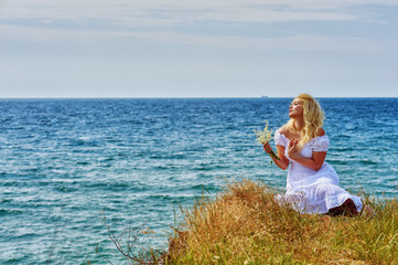 Fototapeta na wymiar Young romantic woman in nature by the sea