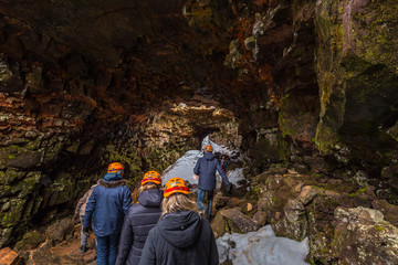 Raufarholshellir - May 04, 2018: Travelers entering the Raufarholshellir lava tunnels, Iceland